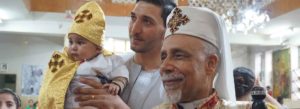 Bishop Kyrillos William and a family at Baptisms at St George's in El Izziyah, near Asyut, Egypt