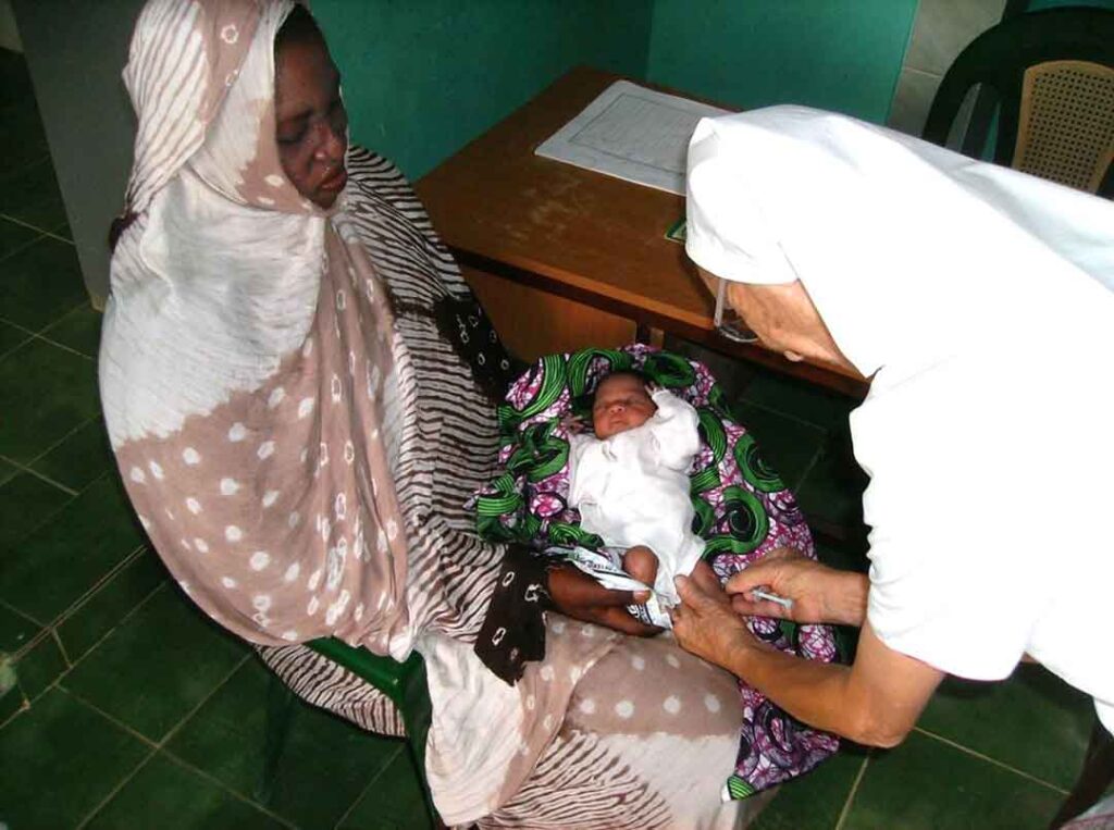 Franciscan Missionary Sisters of Mary. Sister Hilda, at the clinic with a newborn (Toufoundé).