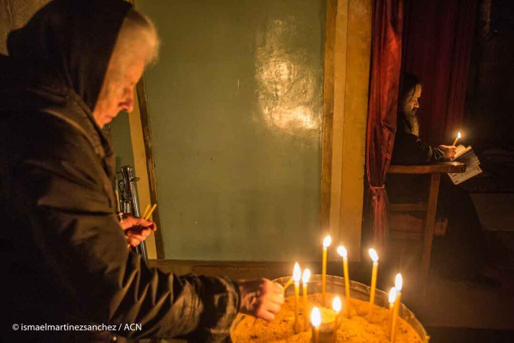 Une pèlerine grecque orthodoxe allume une bougie - Jérusalem