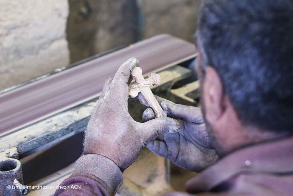 A Palestinian Catholic carpenter observes the filing of a cross in one of the innumerable religious woodwork and handicrafts next to the Basilica of the Nativity (Bethlehem).